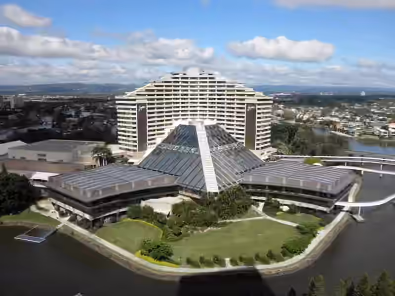 Aerial view from 2010 of the hotel tower on Broadbeach Island, then called Jupiters Hotel and Casino and now The Star Grand, rising behind a glass pyramid roof, with lawns and a canal around the island