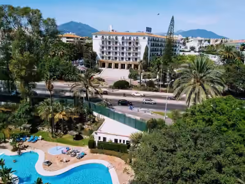 The white hotel building with a tiled roof in Nueva Andalucía that is now the Hard Rock Hotel Marbella, photographed in 2019 when it was the H10 Andalucía Plaza, with the word Casino across its ground floor above a wide flight of steps, and a pool garden in the foreground