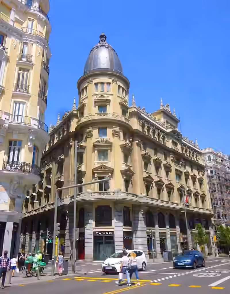 The corner tower and slate dome of the Círculo de la Unión Mercantil e Industrial building at Gran Vía 24 in Madrid, the building that houses Hotel Círculo Gran Vía, with casino signs at street level, photographed in 2021