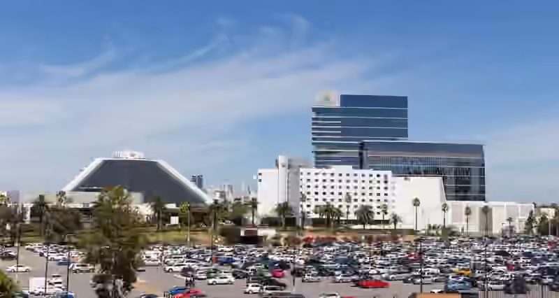 The Crown Perth complex seen across a car park: a low building with a sloping dark roof on the left, white hotel wings and the glass Crown Towers behind