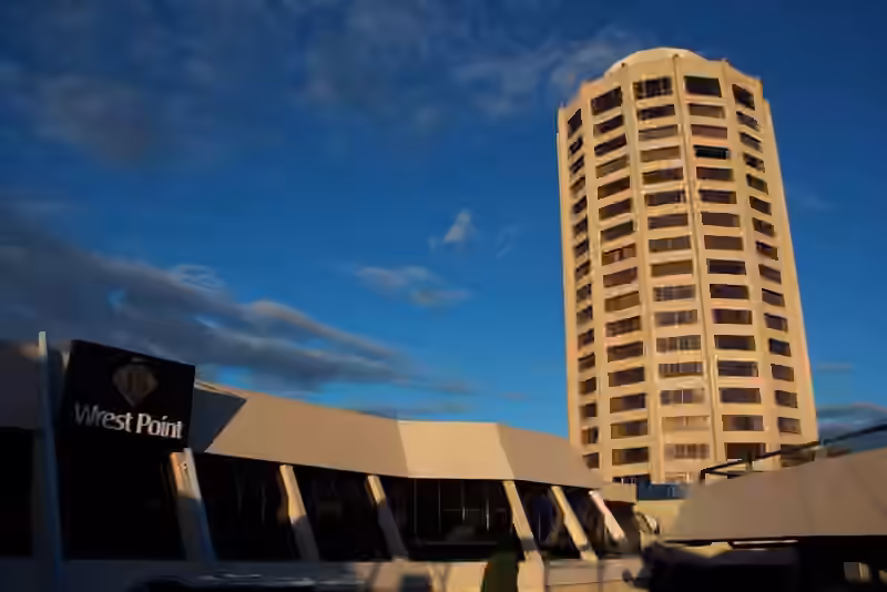 The Wrest Point sign on the low entrance building, with the hotel tower behind it in evening light