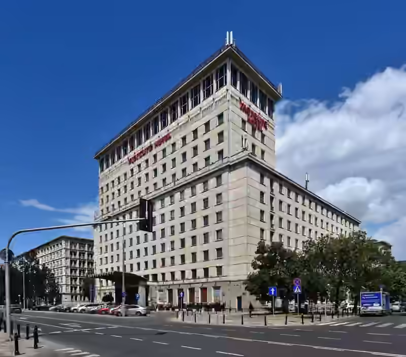 The stone-clad corner block of the Mercure Warszawa Grand hotel, with the Mercure Hotel name in red letters below a glazed top floor