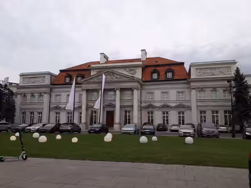 The classicist facade of the Primate's Palace in Warsaw, with the Hotel Bellotto name under the pediment, four columns and a red tiled roof