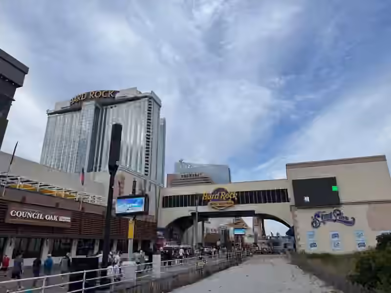 Hard Rock Hotel & Casino Atlantic City seen from the Boardwalk in 2025, with the glass hotel tower and the bridge that carries the Hard Rock sign across to Steel Pier