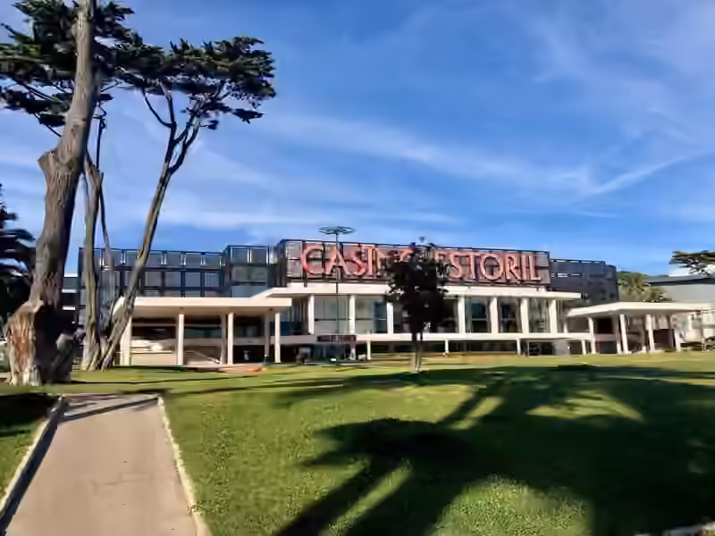 Casino Estoril seen from a path in the garden, with pine trees in the foreground