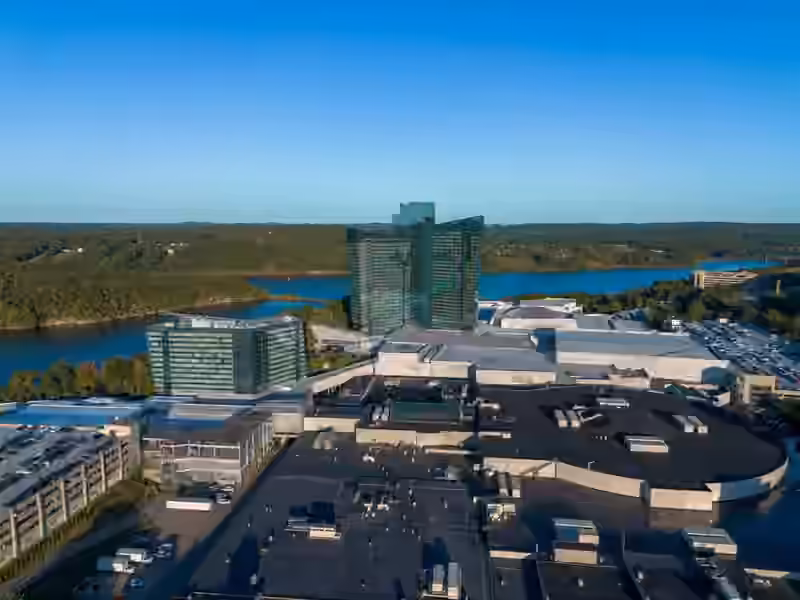 Aerial view of the Mohegan Sun resort in Uncasville with its two glass hotel towers, the Thames River and wooded hills