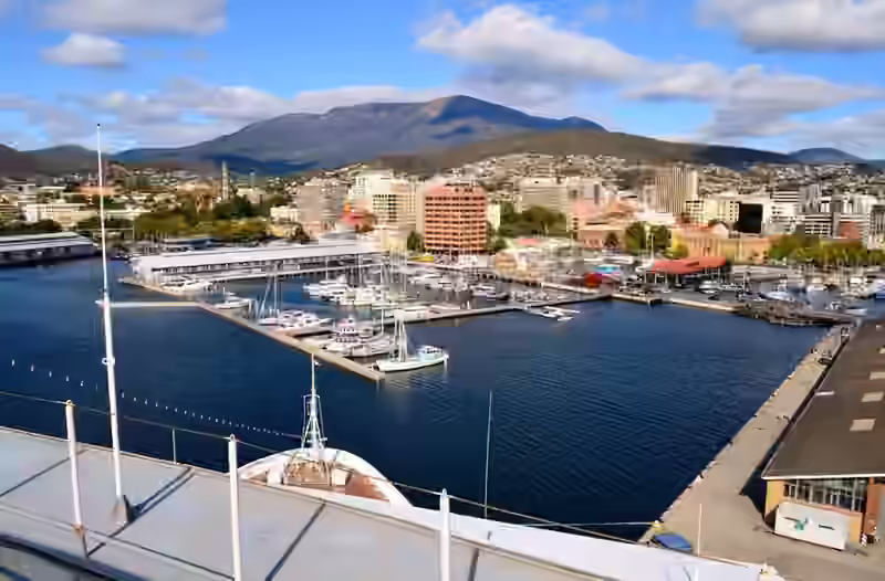 Sullivans Cove in Hobart with boats at the piers, the city behind and kunanyi / Mount Wellington on the horizon
