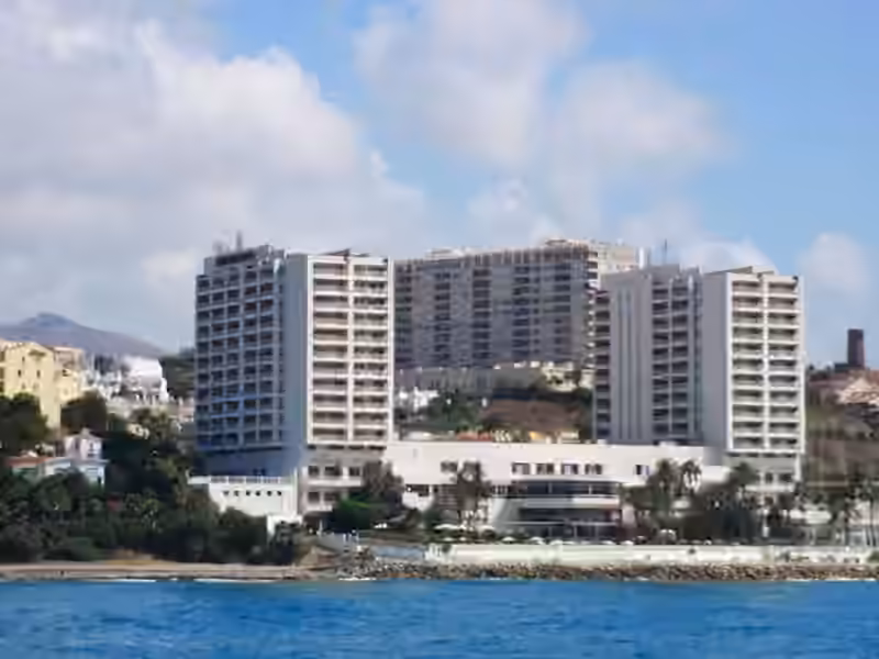 The two white towers of the Hotel Torrequebrada in Benalmádena, the building that also houses Casino Torrequebrada, seen from the sea in 2010 with a low white wing along the shore